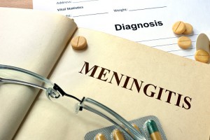 Word Meningitis on a book and pills.