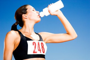 Portrait of a female athlete drinking form a water bottle