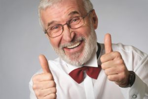 Portrait of a senior man in a tuxedo showing the thumbs up