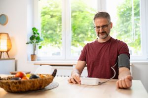 Man measuring blood pressure at home.