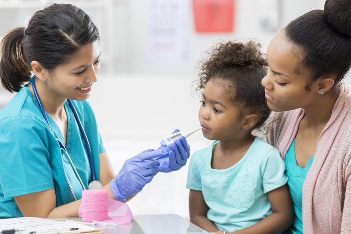 Pediatric Emergency Department – Flushing Hospital Nurse taking temperature of young girl with mother by her side Description: